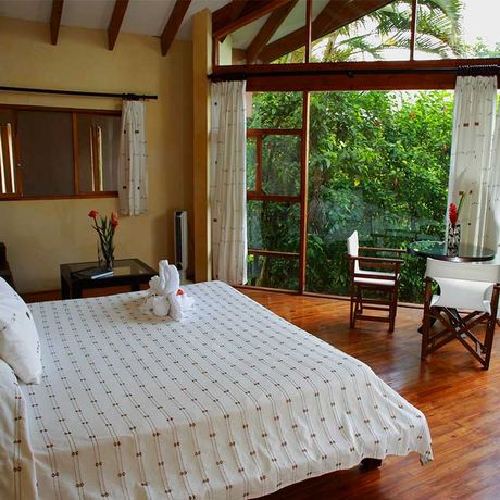 Blick auf ein Bett des Bungalows der Bungalow & Cabina Tenorio Lodge