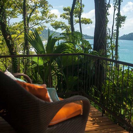 Blick vom idyllischem Balkon auf den Pazifik, umrahmt von tropischem Grün