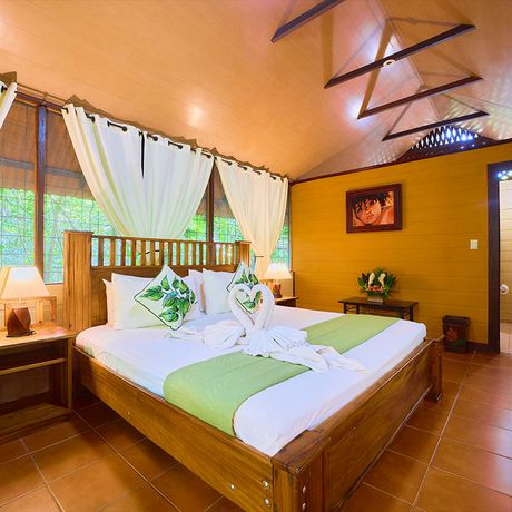 Aninga Lodge Bungalow Doppelbett Blick auf ein Doppelbett