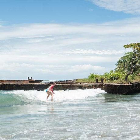Blick auf eine Surferin beim Surfkurs in der Karibik