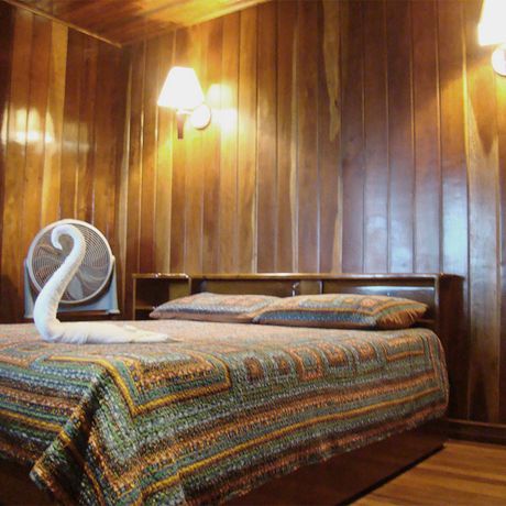Blick auf ein Doppelbett in einem Superiorzimmer der Dschungel-Lodge Miss Junie`s