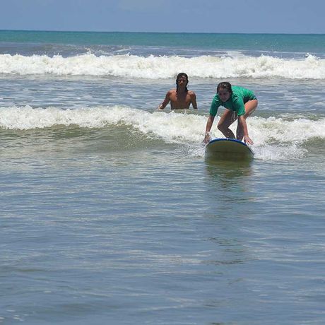 Blick auf eine Surferin beim Surfkurs in Dominical