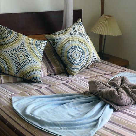 Ein Doppelbett dekoriert mit Kissen und kunstvoll drapierten Handtüchern