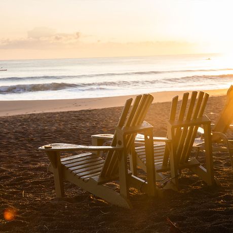 Blick auf gemütliche Stühle am Strand der Strandunterkunft Banana Azul