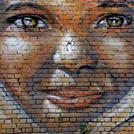Gesicht einer Frau als Graffiti auf Ziegelsteinen