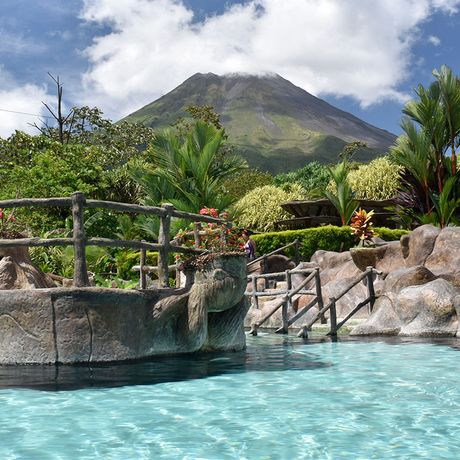 Thermalpool eines Resorts mit Blick auf einen wolkenumhangenen Vulkan 