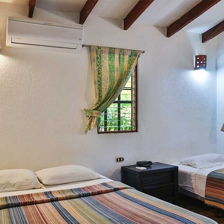 Blick auf zwei Betten des Standardzimmers der Pension Villas Macondo