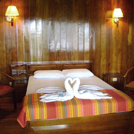 Blick auf ein Doppelbett in einem Standardzimmer der Dschungel-Lodge Miss Junie`s