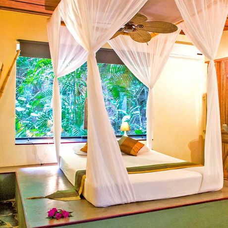 Blick auf das empor gehobene Queensize Doppelbett einer Suite im Hotel Canaima Chill House