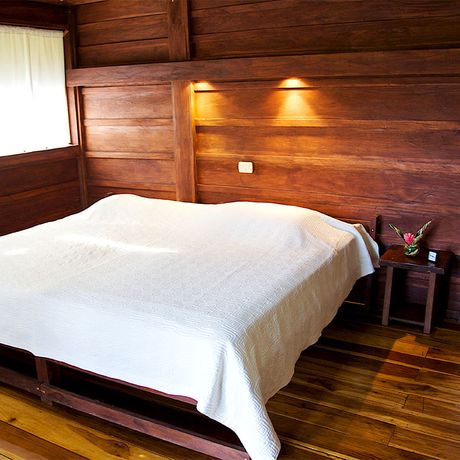 Blick auf ein Doppelbett in der Bungalow Anita Rainforest Lodge