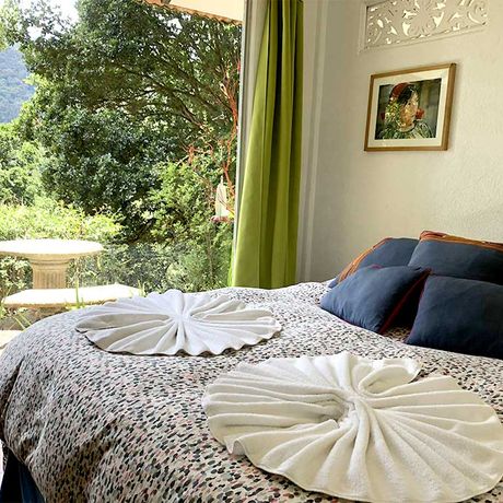 Blick auf ein Bett im Bungalow Standard in der Bungalow Dantica Cloud Forest Lodge